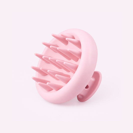 Small pink scalp massager against a light background